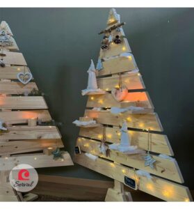 Questa immagine raffigura uno scenario decorato per le festività natalizie, con albero di Natale, decori in legno e design dinterni Una persona è presente per celebrare il festival e augurare Salve Natalem! con le decorazioni natalizie
