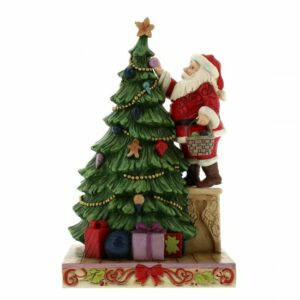 In questa scena di Natale incantevole, un albero di sorbo ornamentato con decorazioni natalizie è circondato da una famiglia di persone Il SantaBambino è in primo piano mentre una donna adulta, una sposa e una donna più anziana, forse la nonna, tengono stretto il Babbo Natale, ricordando a tutti che il Natale è un momento di amore e di gioia condiviso