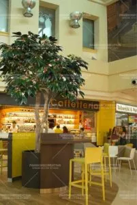 Una scena di un caffè allinterno di un ristorante di un edificio una persona seduta ad un tavolo, circondata da una corte di cibo apparecchiato, con sedia e tavolo allinterno Unesperienza unica di caffè e ristorazione indoor